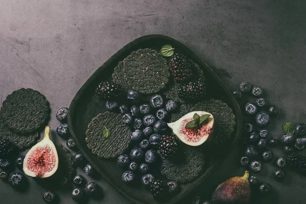 Variedad de bayas e higos con galletas negras — Foto de Stock