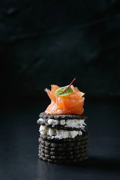 Galletas negras con salmón y bayas —  Fotos de Stock