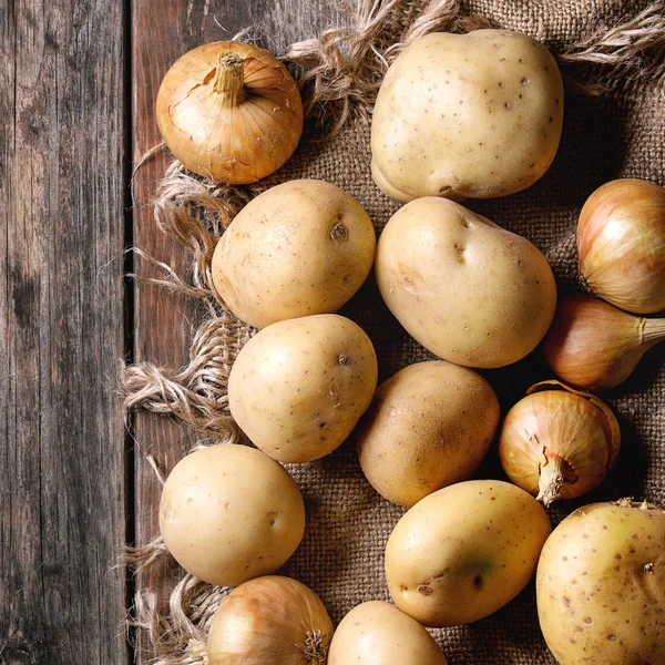 Batatas orgânicas cruas e cebola — Fotografia de Stock