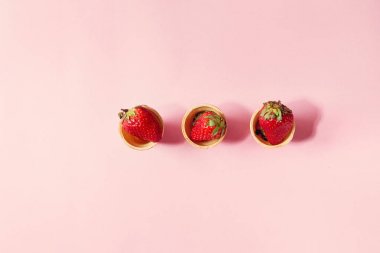 Pembe pastel pin-up arka plan üzerinde gözleme bardak taze çilek. Uzay kopyalayın. Üstten Görünüm