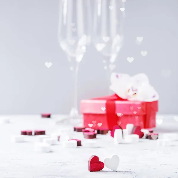 白灰色の背景上バレンタインデーまたは空のシャンパン グラス 赤いギフト ボックス 蘭の花 木心と結婚式挨拶招待カードが大好きです 選択と集中 正方形の画像 — ストック写真
