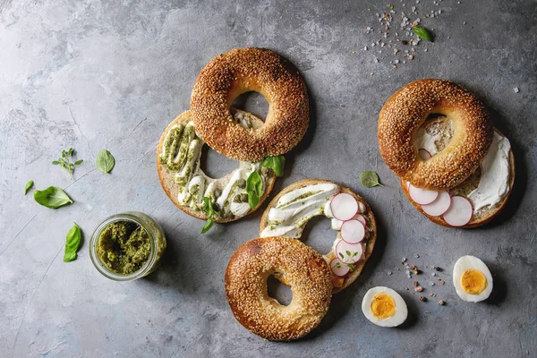 Mängd Olika Hembakade Bagels Med Sesamfrön Färskost Pestosås Ägg Rädisor — Stockfoto