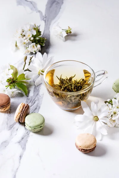 Стеклянная Чашка Горячего Зеленого Чая Французским Десертом Макароны Весенние Цветы — стоковое фото