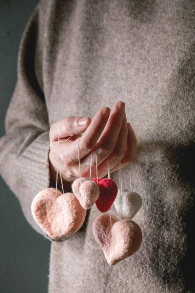 Coeurs feutrés dans les mains féminines — Photo