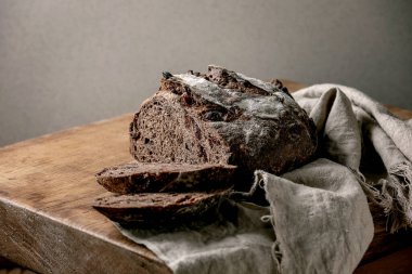 Dilimlenmiş taze zanaatkar ev yapımı çikolata ve yaban mersini ekmeği ahşap mutfak masasının üzerinde keten kumaş üzerinde. Boşluğu kopyala
