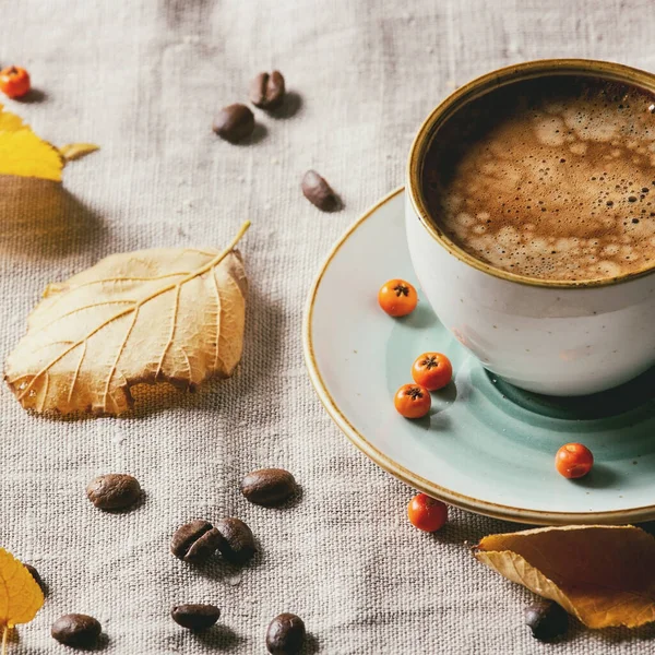 一杯浓缩咖啡 站在亚麻桌布上 有黄色的秋叶 咖啡豆和带深色墙壁的脆饼饼干 秋季概念 复制空间 — 图库照片