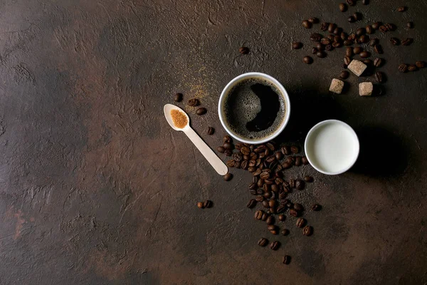 纸杯的美国咖啡和牛奶 回收的木勺甘蔗糖 咖啡豆在黑暗的纹理背景 平坦的地方 — 图库照片