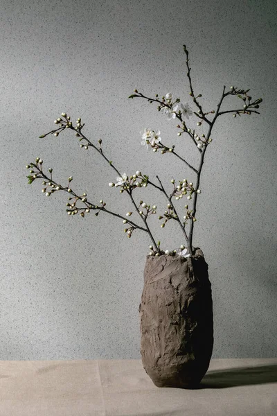 在灰色桌布上的手工粘土花瓶中的花樱桃分枝 春天室内装饰 — 图库照片