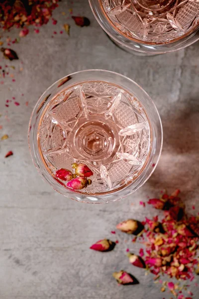 用粉红色玫瑰香槟 苹果酒或柠檬水配干玫瑰芽制成的水晶老式玻璃杯 灰色纹理背景 平坦的地方 — 图库照片