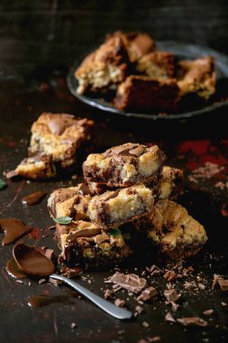 Çikolatalı brookiler, ev yapımı kekler, kareler tarafından dilimlenmiş ev yapımı kekler, çikolata sosu, siyah arka planda naneli şekerler..