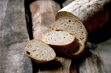 Eski ahşap zemin üzerinde dilimlenmiş tahıllı çavdar-buğday organik ekmek..