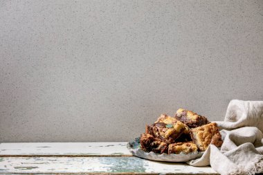 Brookies çikolatalı kekler ve ev yapımı kekler eski beyaz ahşap masada seramik tabakta kareler tarafından dilimlenmiş. Boşluğu kopyala