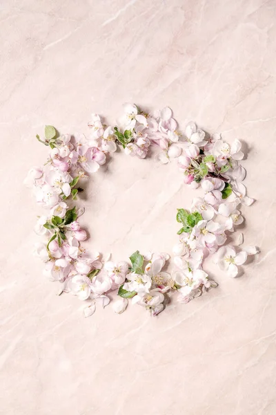 春光明媚的苹果花朵花瓣如圆圆的花环 覆盖在粉色大理石的背景上 复制空间 — 图库照片