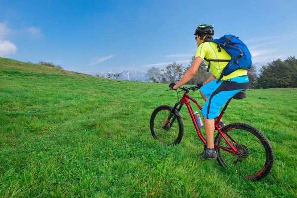 Um jovem macho montando uma bicicleta de montanha ao ar livre — Fotografia de Stock