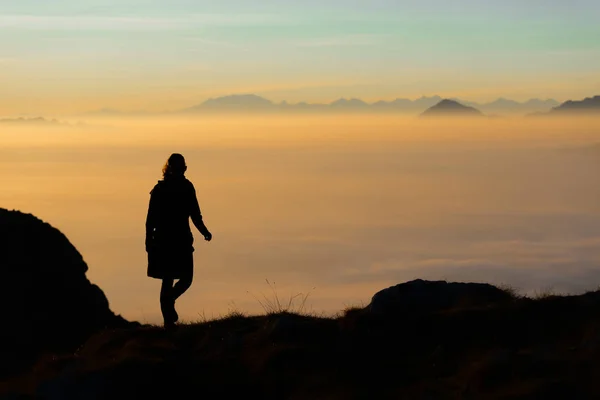 Silhouette d'un randonneur dans les montagnes avec la mer de brouillard dans le th — Photo