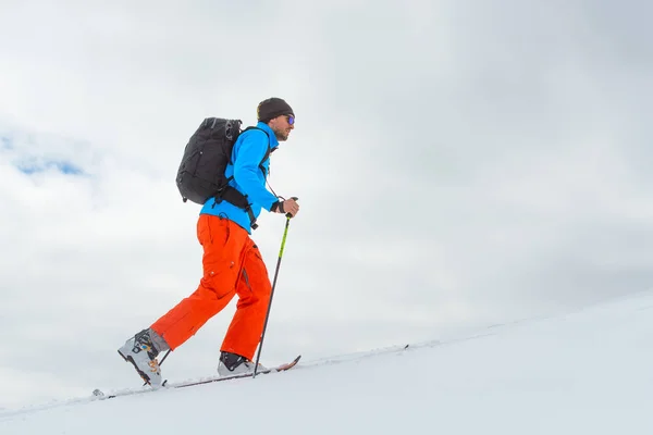 Hombre con esquí de montaña subir hacia la cumbre — Foto de Stock