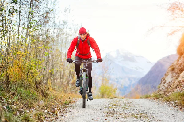 Mountain biker em uma estrada de terra sozinho — Fotografia de Stock