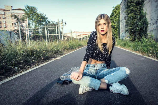 Красивая блондинка сидит на улице в городе — стоковое фото