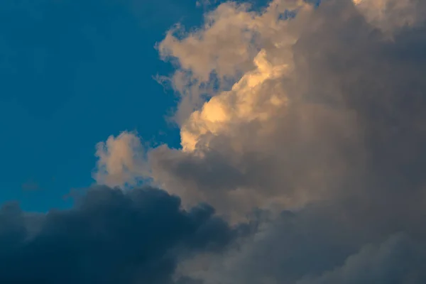 Голубое небо с серыми и красными облаками — стоковое фото