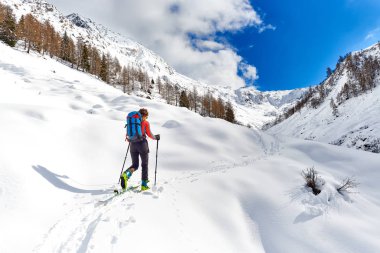 Girl makes ski mountaineering alone clipart
