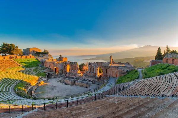 Teatro antigo de Taormina com Etna vulcão em erupção ao pôr do sol — Fotografia de Stock