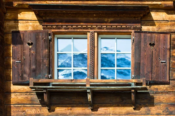 Venster van de typische houten huis in de bergen met gespiegelde mount — Stockfoto