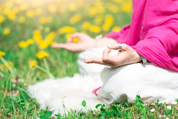 Posición yoga practica es una chica en la naturaleza en flores de primavera — Foto de Stock
