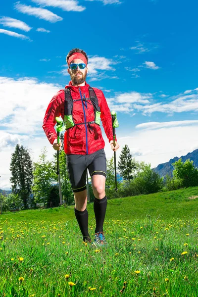 Caminhada nórdica de um homem na primavera no prado — Fotografia de Stock