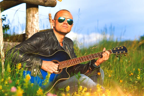 自然草原で一人でギターを持つ歌手を果たしています。 — ストック写真