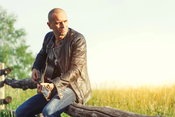 牧草地の塀でギターを持つ歌手 — ストック写真
