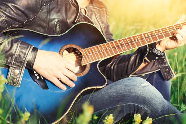 太陽の下で夏の草原でアコースティック ギターを演奏します。 — ストック写真