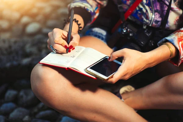 Journalistin macht sich mit Kamera Notizen in Notizbuch — Stockfoto