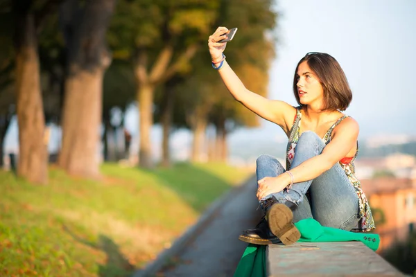 Девушка-подросток делает селфи со смартфоном — стоковое фото