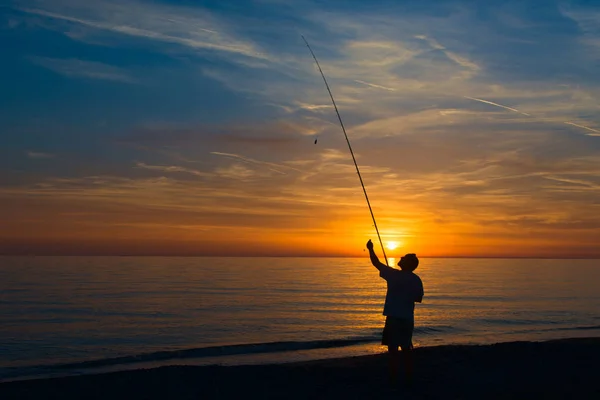Pescador en la orilla del sistema marino la caña de pescar — Foto de Stock