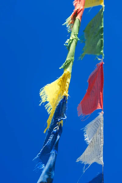 Rangées verticales de drapeaux de prière bouddhistes tibétains colorés agitant i — Photo