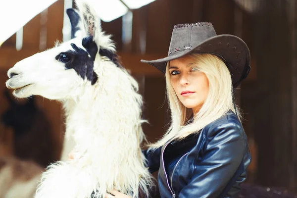 Bella donna bionda in stile country con un lama bianco — Foto Stock