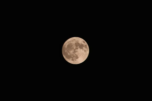 Полная желтая луна на фоне тёмного неба — стоковое фото