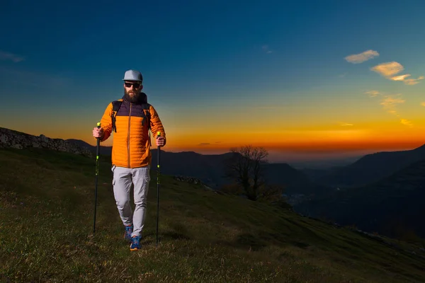 カラフルな太陽の下でノルディックウォー キングを練習してひげを持つ若者 — ストック写真