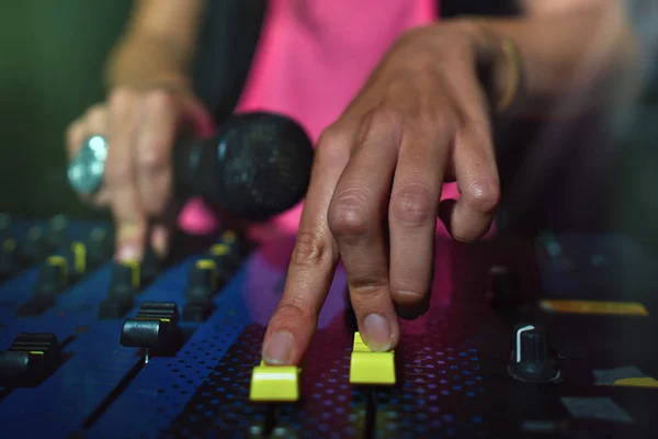 Close-up de mãos femininas em um console deejay com microfone — Fotografia de Stock