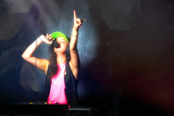 Chica glamurosa deejay en el trabajo cantando en su consola en una fiesta —  Fotos de Stock