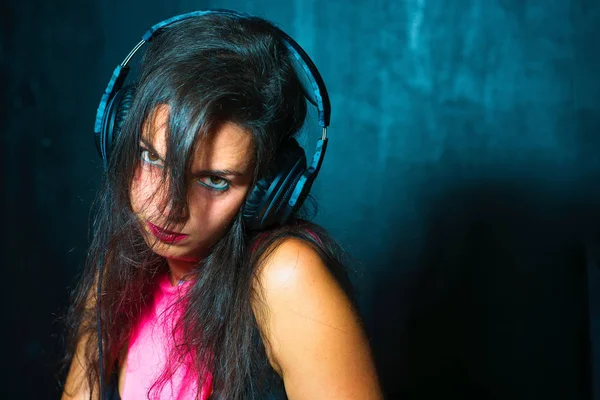 Pretty expressive girl deejay with headphones on her console at — Stock Photo, Image