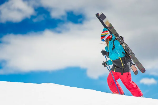 Tjej freeride skidåkare, skala berget innan nedstigningen — Stockfoto