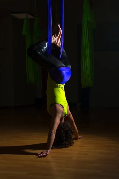 Hezká dívka praktiky antigravitační jóga pozice v tělocvičně na blu — Stock fotografie