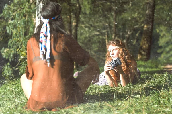 Bastante gratis hippie niñas en la hierba tomando fotos con un viejo — Foto de Stock