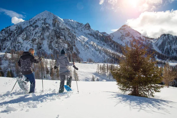 Corre con raquetas de nieve. una pareja se divierte en las montañas — Foto de Stock