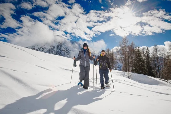 Junges Paar unternimmt Schneeschuhwanderungen in den Bergen — Stockfoto