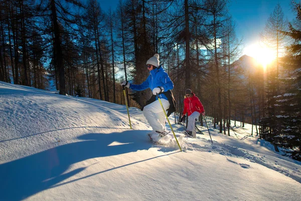 Excursie met sneeuwschoenen door twee vrouwen bij zonsondergang — Stockfoto
