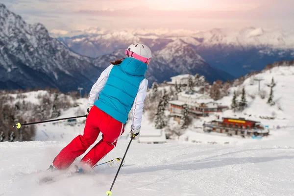 Sportig tjej skidåkning mot alpin kojan — Stockfoto