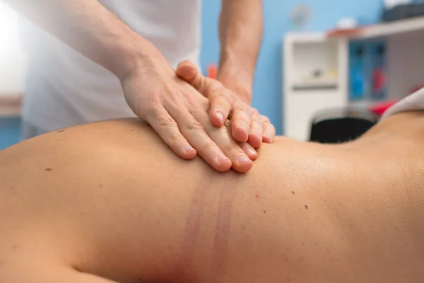 Physiotherapist performs a back massage — Stock Photo, Image