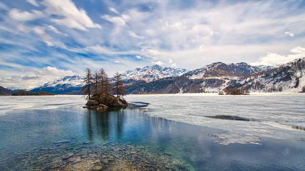 Engadin vallei. Lente dooi met eilandje op het meer — Stockfoto